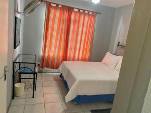 a bedroom with a bed and a window with an orange curtain at Bela-Bela Pendleberry Grove Unit 3 in Bela-Bela +43 photos
