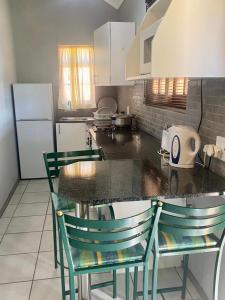 a kitchen with a counter with chairs and a refrigerator at Bela-Bela Pendleberry Grove Unit 3 in Bela-Bela
