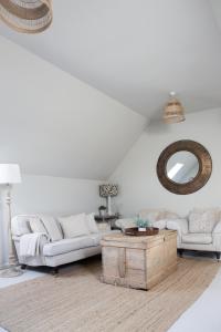 uma sala de estar com um sofá branco e uma mesa em Beautiful spacious rural retreat 1 bedroom self contained annex 