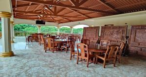 comedor con mesas y sillas de madera en Hotel Pacific Pearl - Playa Los Destiladeros, en Los Destiladeros