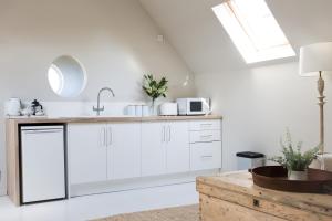 eine Küche mit weißen Schränken und einer Spüle in der Unterkunft Beautiful spacious rural retreat 1 bedroom self contained annex in Filgrave