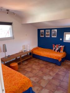 a bedroom with two beds and a blue wall at Attique à Banyuls - vue mer et montagne in Banyuls-sur-Mer