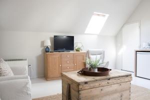 een woonkamer met een tv en een houten salontafel bij Beautiful spacious rural retreat 1 bedroom self contained annex 