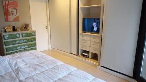 a bedroom with a bed and a tv in it at Fabuloso departamento en complejo residencial in Yerba Buena