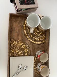 a wooden tray with two cups and spoons at Samarkanda Apartamento- Suite con espectacular vista panorámica in Las Negras