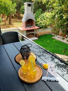 a table with two glasses of orange juice and a pizza oven at Apartment by the sea Renata in Punta Skala in Petrcane