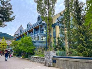 a blue building with people walking in front of it at Village Gate House by Whiski Jack in Whistler