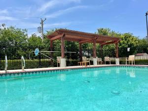 uma piscina com um gazebo de madeira e uma piscina em Best Western Roanoke Inn & Suites em Roanoke