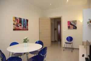 トリノにあるAppartamento Elenaの白いテーブルと青い椅子が備わる客室です。