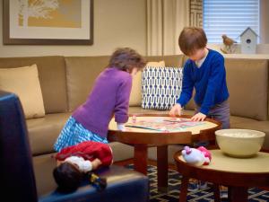 a boy and a girl playing a game in a living room at Sonesta ES Suites Houston Galleria in Houston