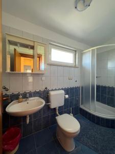 a bathroom with a toilet and a sink at Apartments Akiki in Karlobag +29 photos