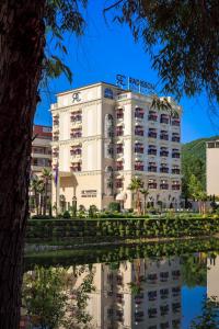 Radisson Collection Morina Hotel, Tirana في تيرانا: مبنى ينعكس على هيئة ماء
