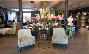 una tienda con mesa, sillas y flores en Blarney Woollen Mills Hotel - BW Signature Collection, en Blarney
