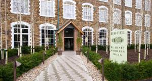 a brick building with a sign in front of it at Blarney Woollen Mills Hotel - BW Signature Collection in Blarney