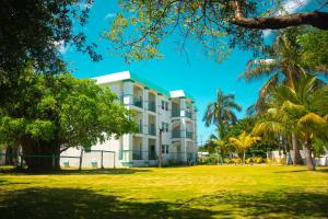 サン・ペドロにあるBest Western Grand Baymen Gardensの前にヤシの木がある建物
