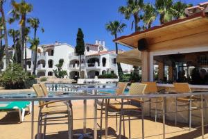 a patio with chairs and a table and a building at Apartamento recién reformado en Cala en Porter in Cala en Porter