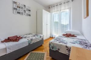 1 dormitorio con 2 camas y ventana en Krmpotic, en Crikvenica