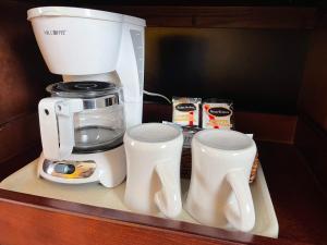 a coffee maker and cups sitting on a shelf at Governors Inn Hotel Sacramento in Sacramento