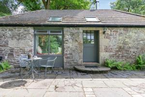 a small stone house with a table and chairs at The Studio in Doune