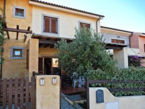 a house with a wooden fence in front of it at La Casa Degli Specchi-villetta con due giardini in La Maddalena