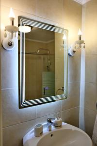 uma casa de banho com um lavatório e um espelho grande em Castellmare em Lepanto