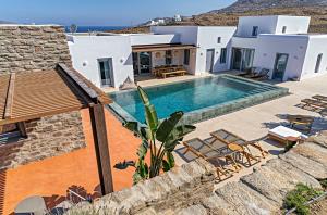 een villa met een zwembad en een huis bij Cape Ftelia in Ftelia