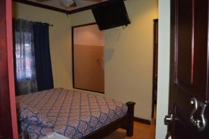 Dormitorio pequeño con cama y espejo en Hotel CR Lounge by Little Havana en San José