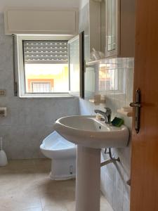 La salle de bains est pourvue d'un lavabo, de toilettes et d'une fenêtre. dans l'établissement Casa vacanze CoMì, à Santa Maria del Cedro