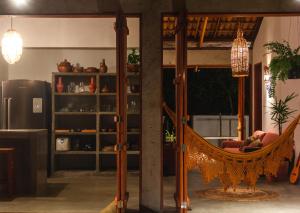 a hammock in the middle of a living room at Casa Canoa - Praia de Algodões in Marau