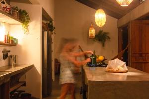 a woman is standing in a kitchen preparing food at Casa Canoa - Praia de Algodões in Marau