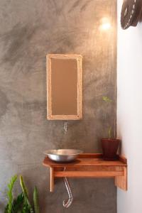 a bathroom with a sink and a mirror on a table at Casa Canoa - Praia de Algodões in Marau