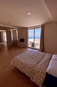 a bedroom with a bed and a large window at VILLA ZEN TAORMINA in Taormina