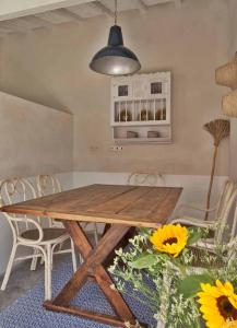 a dining room with a wooden table and chairs at Casa de Cantoneiros, Comporta in Torroal