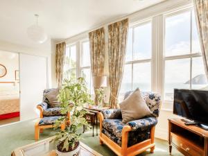 a living room with two chairs and a television at Clooneavin Apartment 3 in Lynmouth