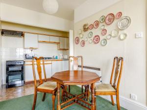 a kitchen with a table and chairs and plates on the wall at Clooneavin Apartment 3 in Lynmouth
