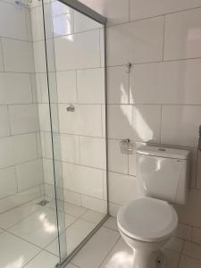 a bathroom with a toilet and a glass shower at Hotel Dallas Toríbio in Bom Jesus da Lapa