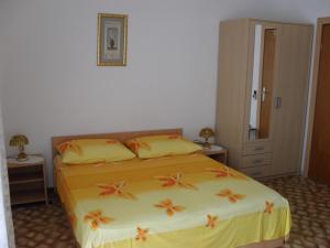 1 dormitorio con 1 cama con sábanas amarillas y almohadas de color naranja en Apartments Atlantida, en Marina
