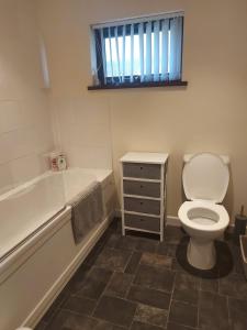 y baño con aseo, bañera y lavamanos. en 10 The Parklands - Cosy Bungalow in Cornwall, en Kilkhampton