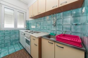 cocina de azulejos azules con fregadero y fogones en Rooms by the sea Gradac, Makarska - 16006, en Gradac