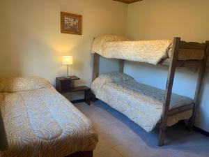 Zimmer mit 2 Etagenbetten und einer Lampe in der Unterkunft Las Rucas in San Martín de los Andes