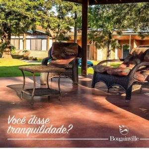 twee stoelen en een tafel op een patio bij Bougainville Hotel Fazenda in Amparo