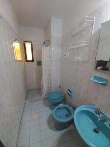 y baño con aseo azul y lavamanos. en Edificio Trebol - Departamento en pleno centro de Carlos Paz en Villa Carlos Paz