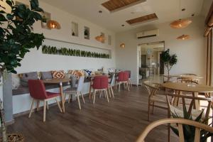 a restaurant with wooden tables and red chairs at شـاطئ الجـار in Rayyis