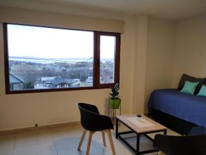 een slaapkamer met een bed en een groot raam bij Mirador de Alem Apartments in Ushuaia