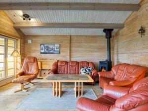 a living room with leather furniture and a table at 6 person holiday home in Slagelse in Slagelse