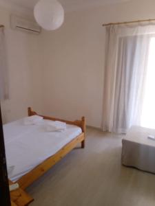 a small bedroom with a bed and a window at ROUSETIS APARTMENTS in Aigio