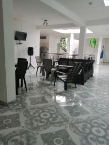 a lobby with chairs and a table and a television at Helena Hostel in Cali