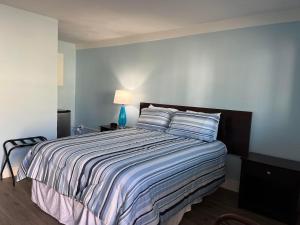 um quarto com uma cama grande e um edredão listrado em Pete's Lakefront Motel, LLC em Geneva
