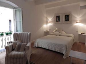 a bedroom with a bed and a chair at La dimora del Conte Bracco B. in Albenga