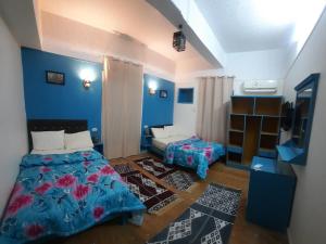 開羅的住宿－happy life hostel，一间拥有蓝色墙壁的卧室,配有一张床和一张桌子